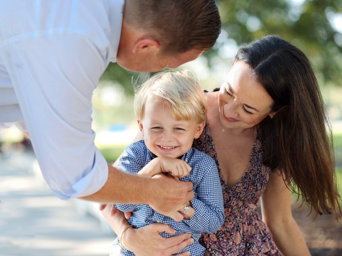 Parents playing with their toddler son outdoors