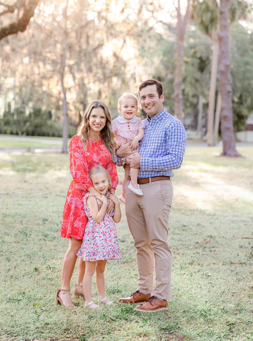 Family of four portrait in a wooded setting at golden hour